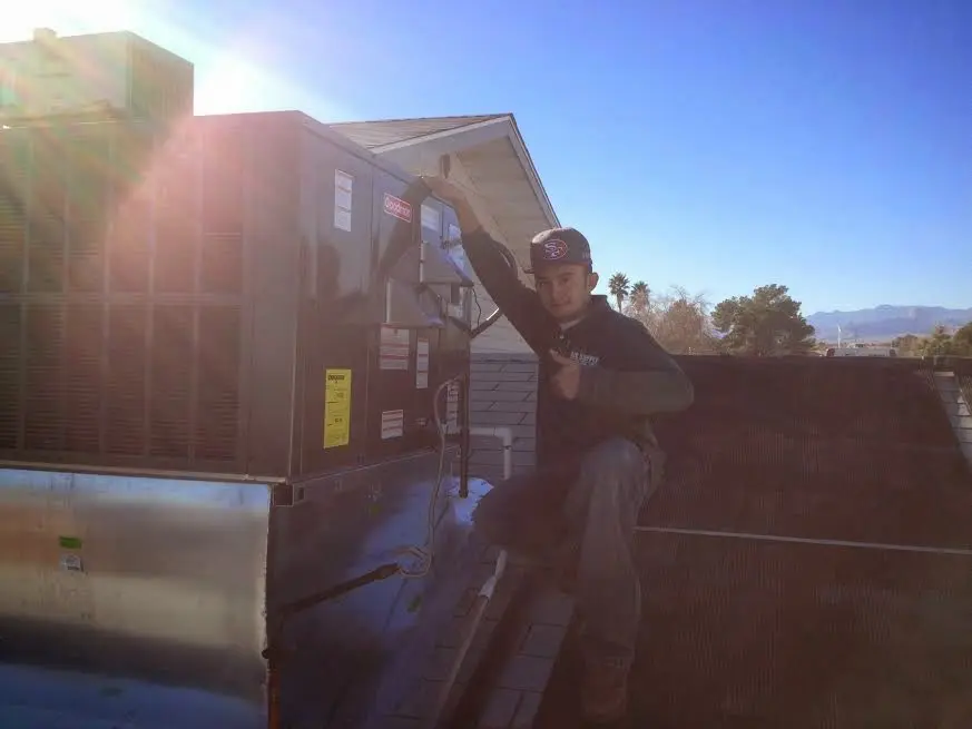 HVAC technician performing AC Tune-Up on a rooftop unit in Independent Hill
